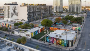 Wynwood Miami with colorful mural-covered warehouses and modern residential buildings rising behind them